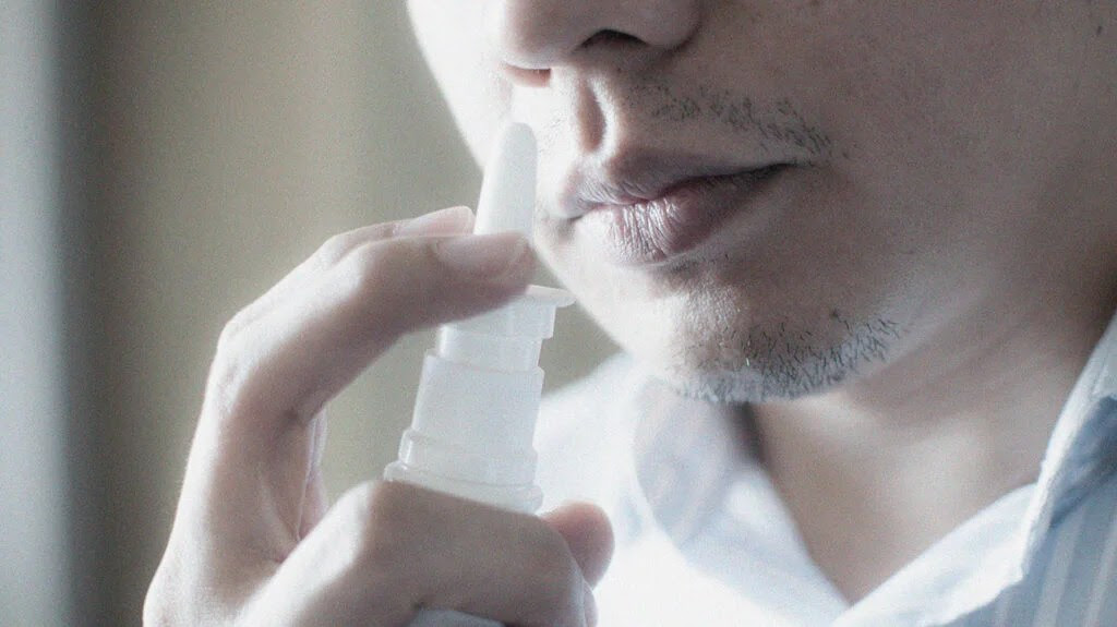 close up of man about to use nose spray