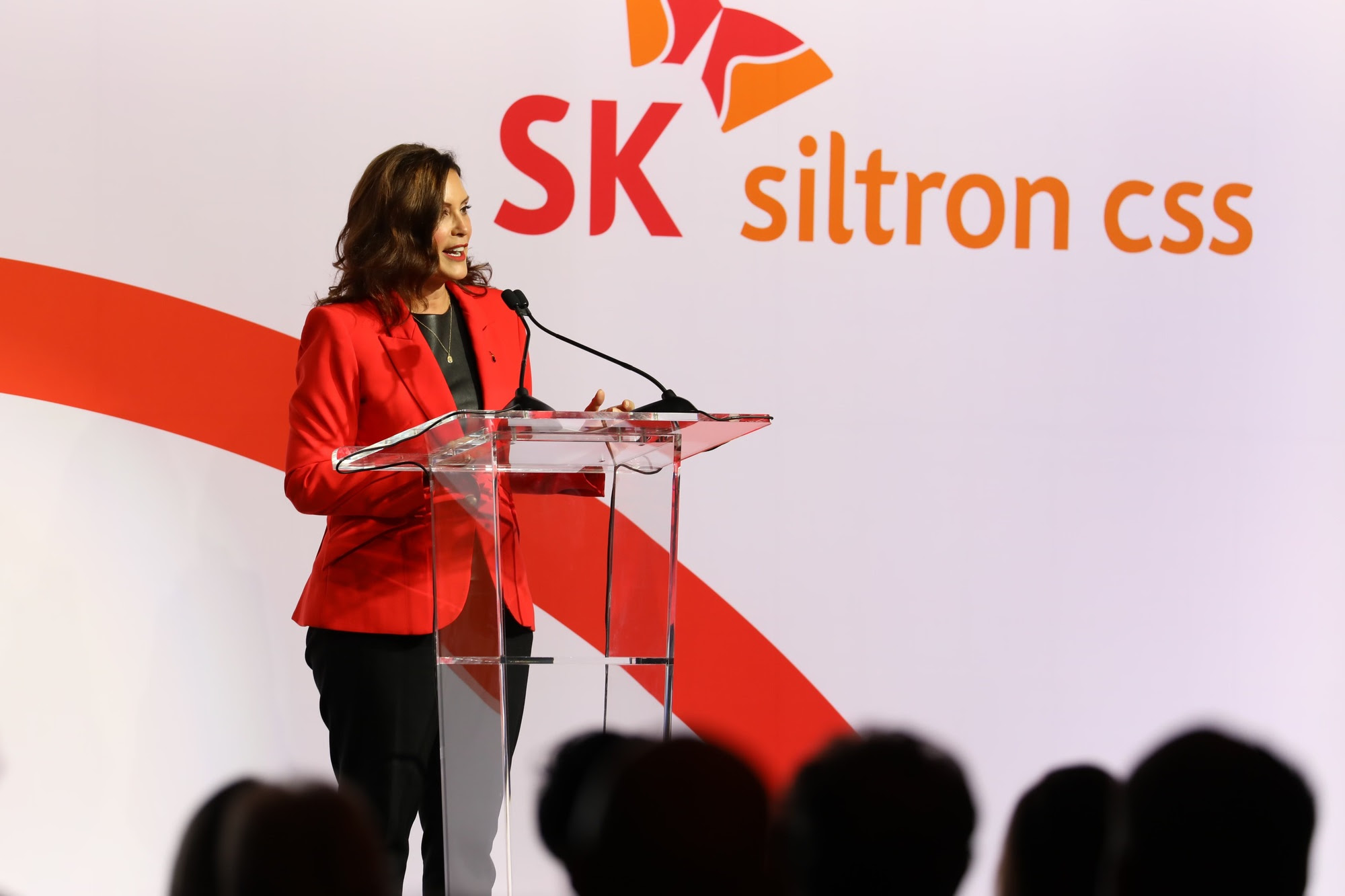 Gov. Whitmer speaks at podium during the ribbon cutting and tour event 