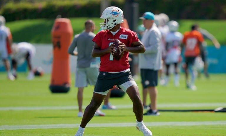 Tua Tagovailoa (#1) drops back to pass in Miami Dolphins training camp for 2022