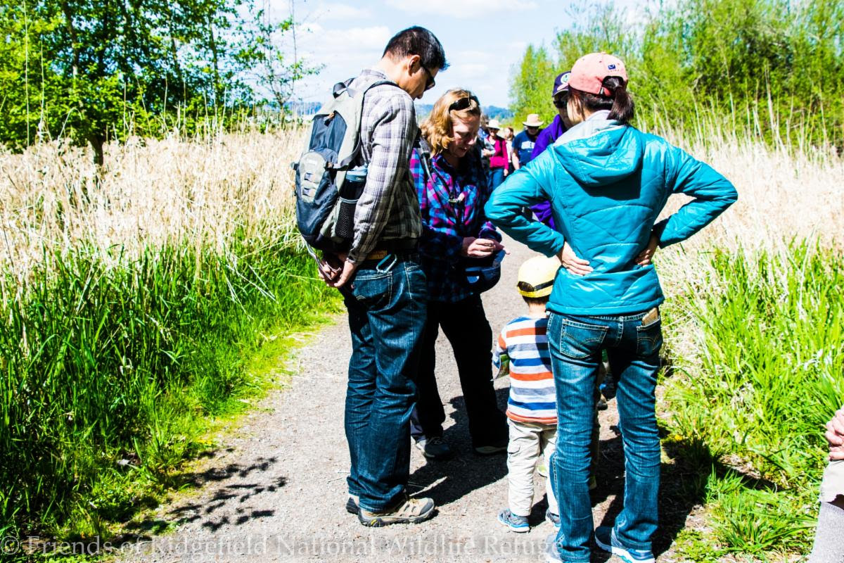 Volunteers stop during a training hike to engage with a family