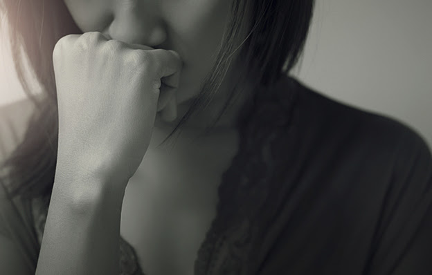 A sad woman with her hand on her face.