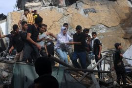 A woman is helped down from a building destroyed during Israeli attacks on Rafah in the southern Gaza Strip, on November 11 [Said Khatib/AFP]