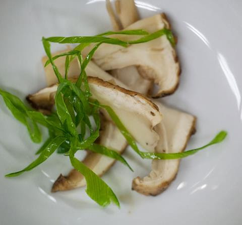 sliced mushrooms with garnish on a white plate