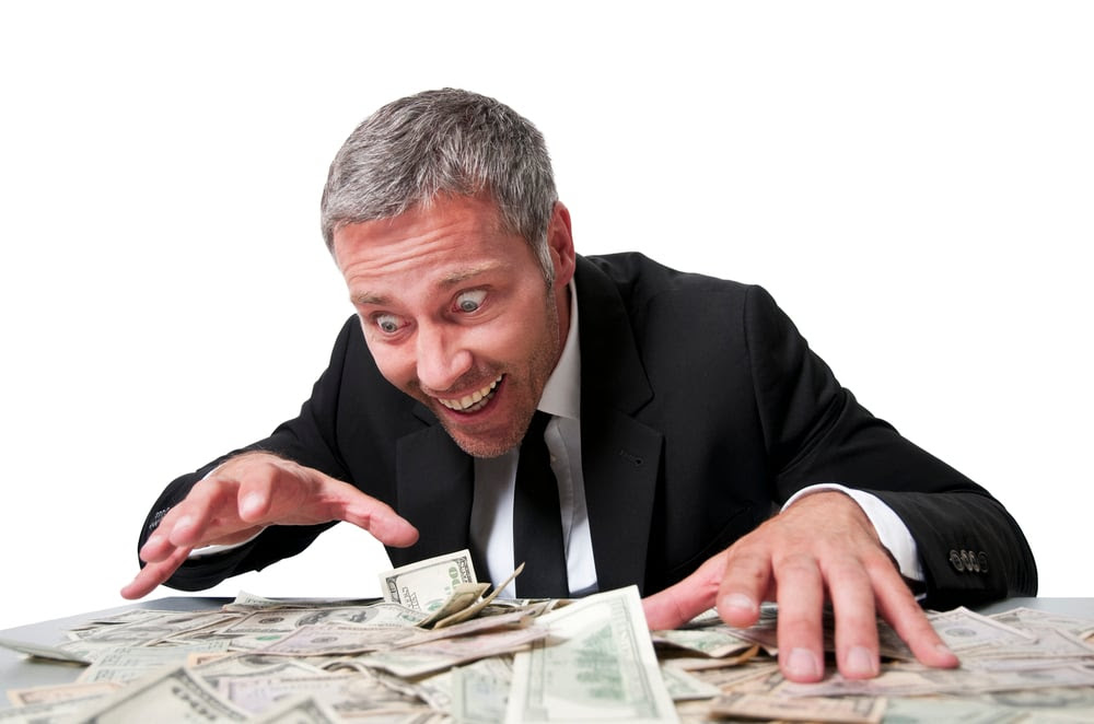 Man looking over a pile of money excitedly