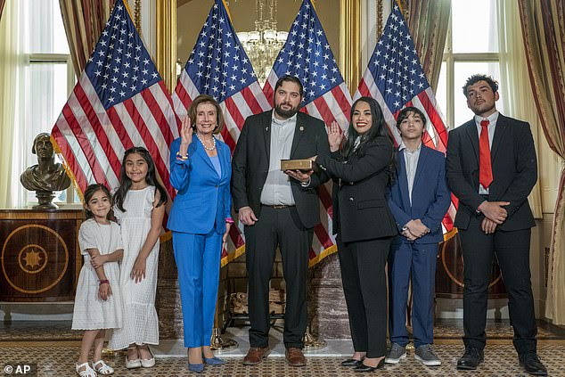Flores' husband is a Border Patrol agent. He is pictured (center) holding the Bible Flores (right of him) used to be sworn in as a U.S. Representative when she succeeded a Democratic congressman who left his term early to become a lobbyist