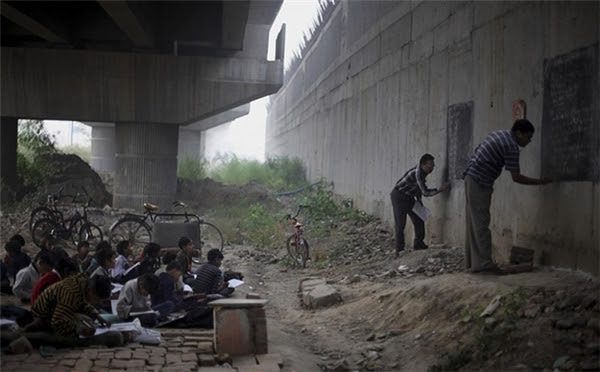 Hai giáo viên tốt bụng dạy chữ miễn phí cho trẻ em nghèo bên dưới một cây cầu vượt ở New Delhi, Ấn Độ.