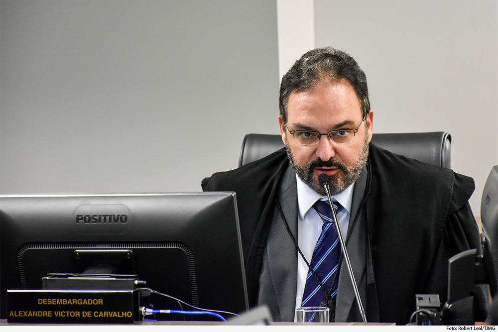 Homem fala ao microfone em sessão de julgamento