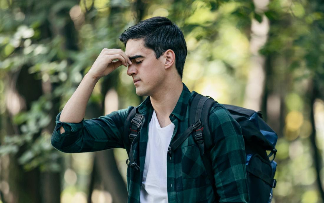 a man hiking who is experiencing allergies and dizziness