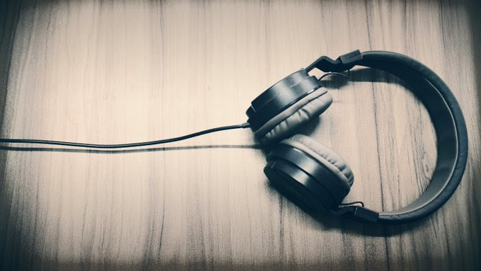 Black headphones lying on vintage wood surface
