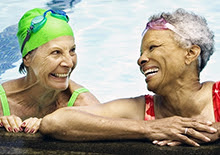Two smiling women in a swimming pool.