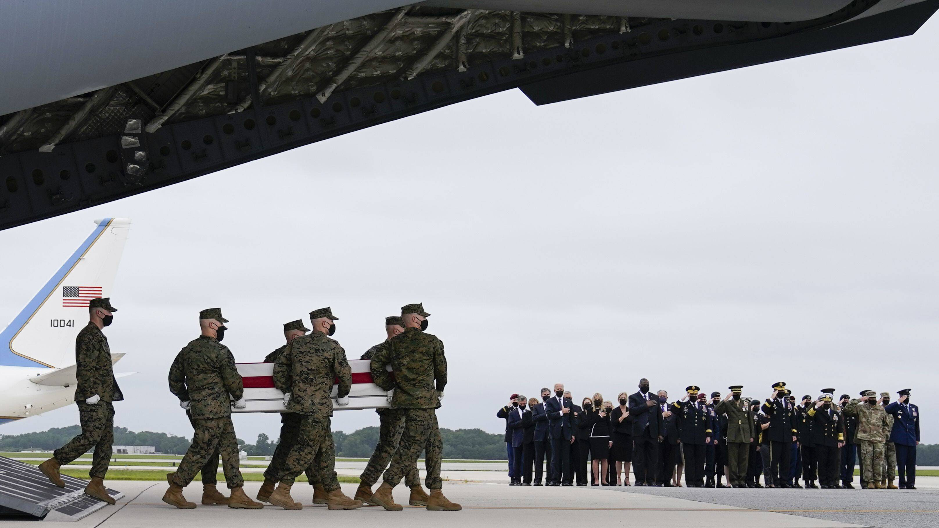 President Biden, first lady Jill Biden and others watch as a Marine Corps team carries the remains of Marine Corps Lance Cpl. Jared M. Schmitz, 20, during a casualty return on Aug. 29 at Dover Air Force Base in Delaware. (Carolyn Kaster/AP)