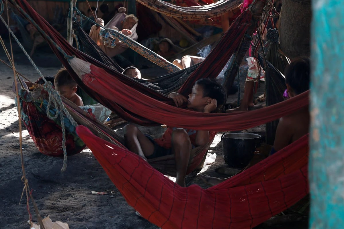 Crianas yanomami descansam em redes dispostas em cmodo de construo indgena tradicional