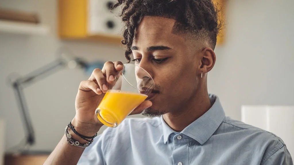 a man drinking fruit juice as it's one of the home remedies for diverticulitis