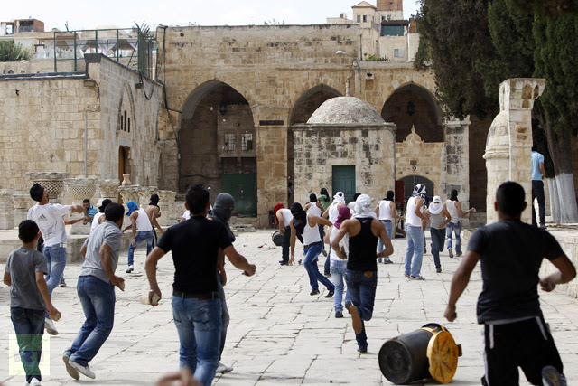 Palestinian youths throw stones during clashes with Israeli security forces near al-Aqsa mosque in Jerusalem's Old City