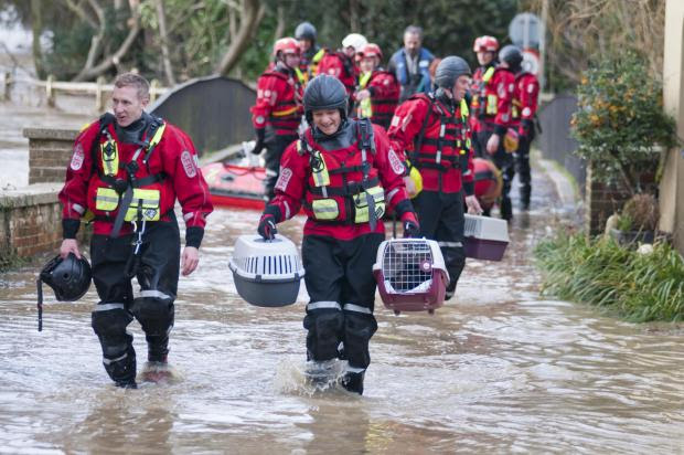 This Is Local London: A couple and their pets are rescued by boats from their home in Thorncroft Drive on Christmas Eve