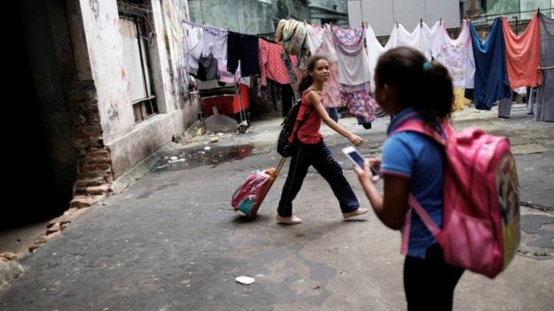 crianças na ocupação Prestes Maia, antiga fábriga textil, com mochilas escolares