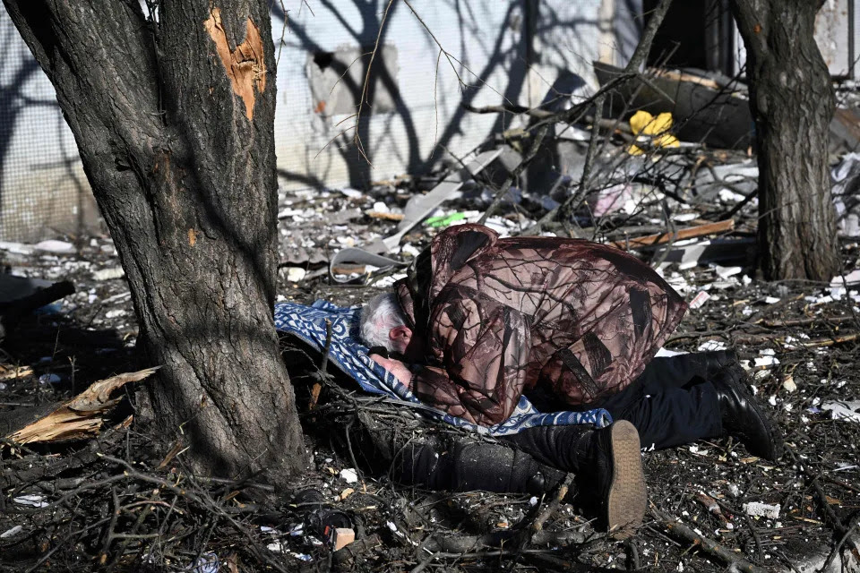 A man reacts at the body of a relative outside a destroyed building after bombings on the eastern Ukraine town of Chuguiv on Feb. 24, 2022. <span class=copyright>Aris Messinis/AFP via Getty Images</span>