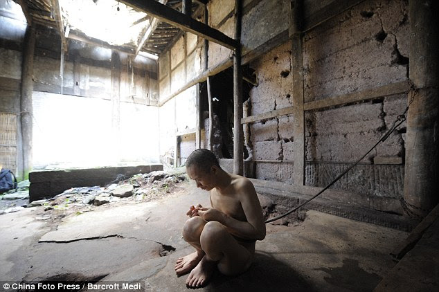 Chained: According to his mother Tang, 40, has to be kept naked because he rips his clothes 