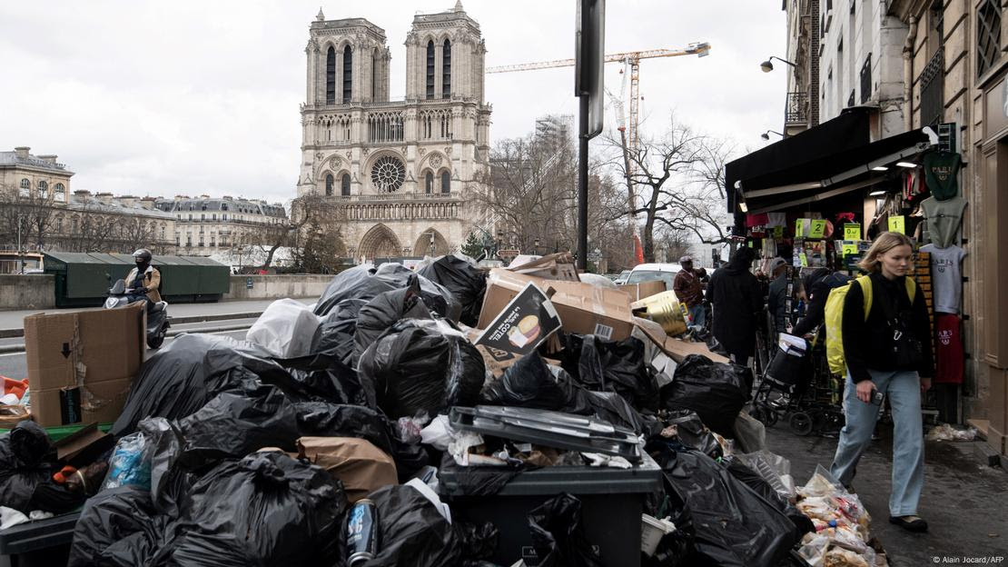 Sacos de lixo amontoados em rua de Paris, com a Notre Dame ao fundo Sacos de lixo amontoados em rua de Paris, com a Notre Dame ao fundo