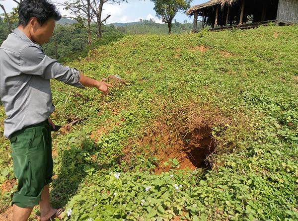A villager points to where a bomb landed in Kachin State.