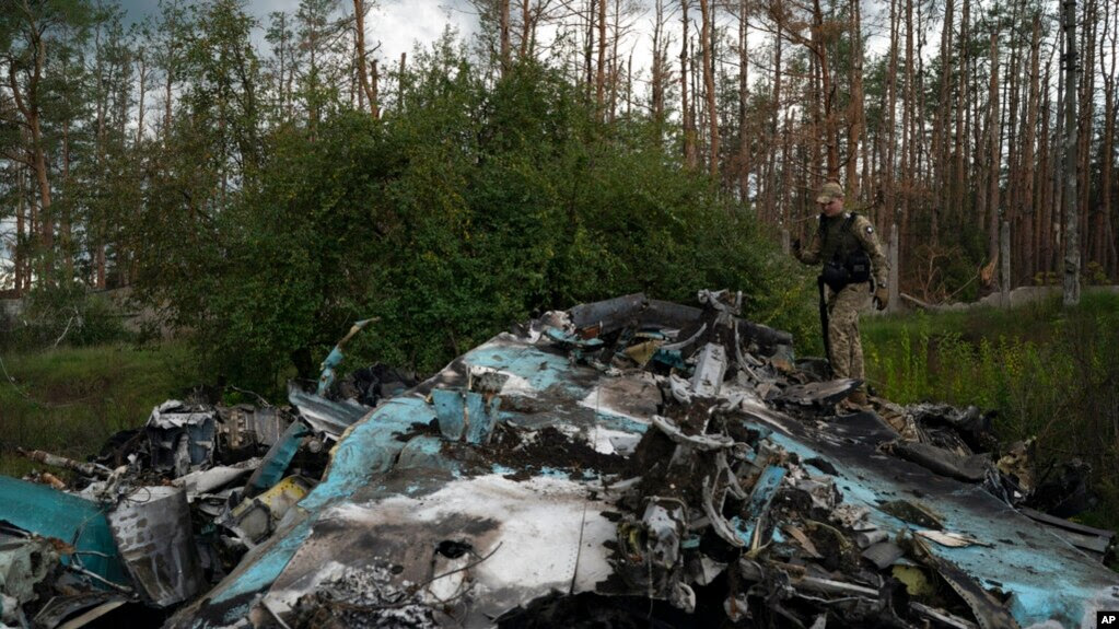 Binh sỹ Ukraine bước trên xác máy bay SU-34 của Nga ở thành phố Lyman mà họ tái chém từ quân Nga 