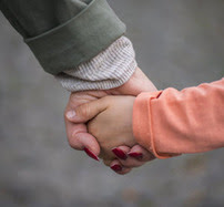 adult and child holding hands