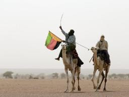 A man holds the flag of the National Movement for the Liberation of Azawad (MLNA) during a demonstration in support of the MLNA on July 28, 2013 in Kidal, northern Mali