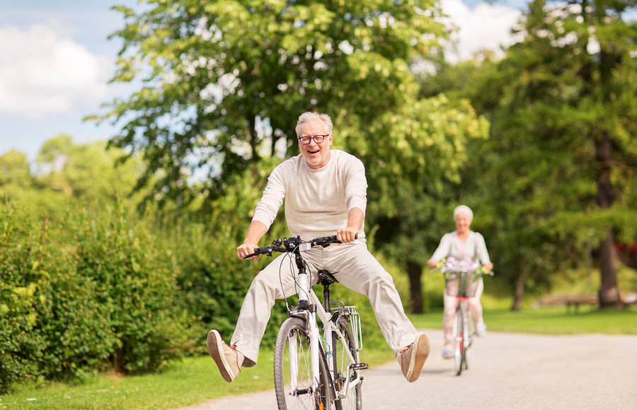 A happy elderly retired couple joyfully riding their biikes