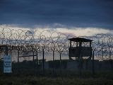 In this photo reviewed by U.S. military officials, the sun sets behind the closed Camp X-Ray detention facility, Wednesday, April 17, 2019, in Guantanamo Bay Naval Base, Cuba. (AP Photo/Alex Brandon)