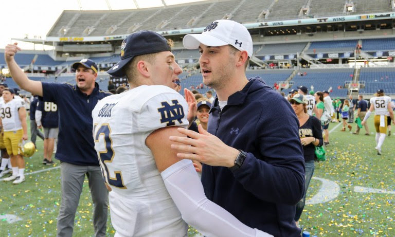 Notre Dame OC Tommy Rees on the field with QB Ian Book after a game.