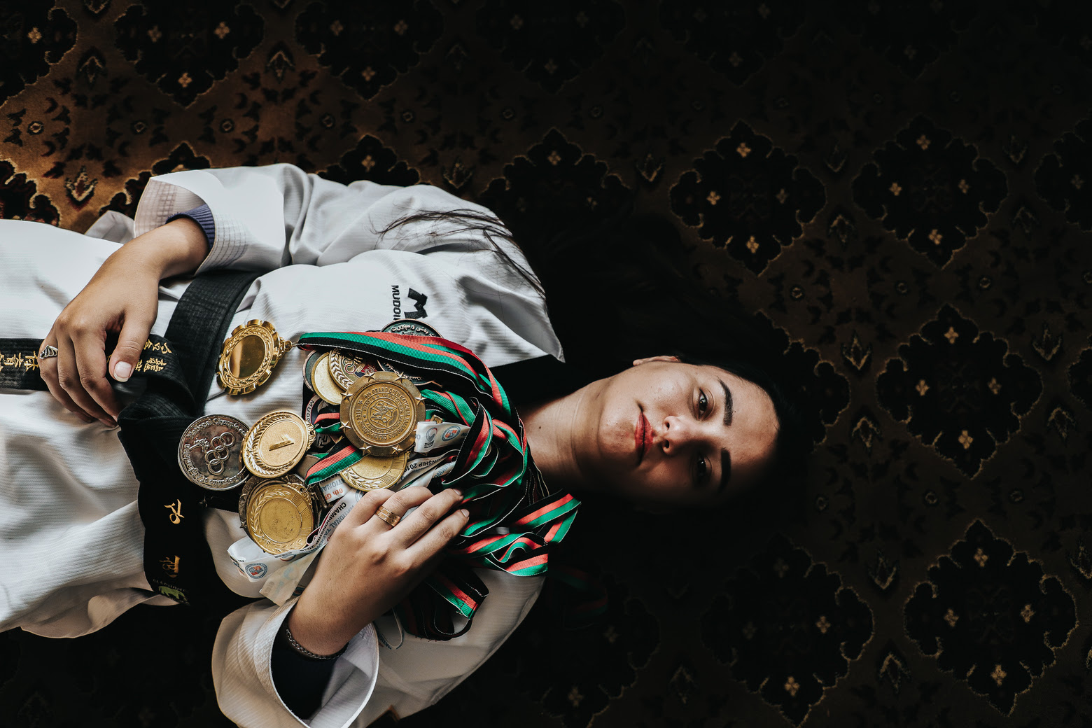 une femme, en Afghanistan, est allongée sur le dos, ses médailles sur elle