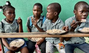 Niños de Haití comen una comida suministrada en el marco del programa de alimentación escolar del PMA.
