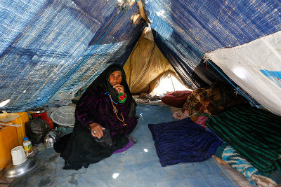 Internally displaced woman in her temporary shelter in an informal settlement on the outskirts of Herat city