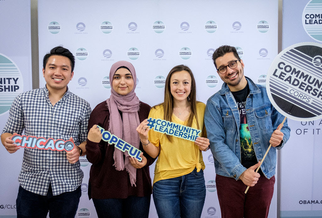 The four young leaders of Info 312 pose with the #CommunityLeadership and other decals.