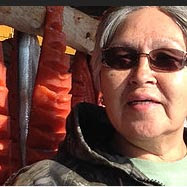 Woman with drying salmon in background