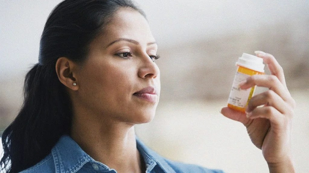 A person preparing to take their dose tizanidine.