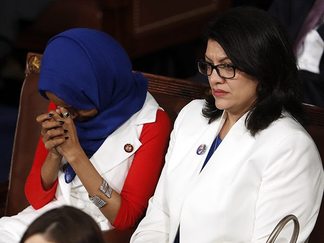 Rep. Ilhan Omar, D-Minn., left, and Rep. Rashida Tlaib, D-Mich., right, listen as President Donald Trump delivers his State of the Union address to a joint session of Congress on Capitol Hill in Washington, Tuesday, Feb. 5, 2019. (AP Photo/J. Scott Applewhite)