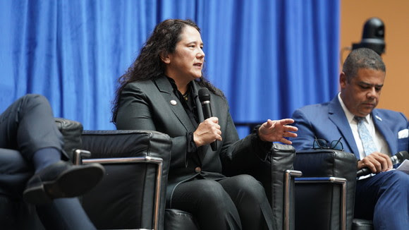 One person sitting on a stage inside.