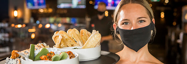 Waitress wearing face mask, ready to serve customers.