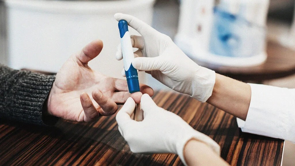 close up of a person's hand having their blood sugar tested