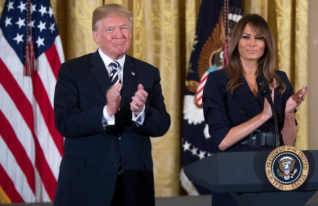 US President Donald Trump stands alongside First Lady Melania Trump (R) during an event in honor of Military Mothers and Spouses in the East Room of the White House in Washington, DC, May 9, 2018. (Photo credit: SAUL LOEB/AFP/Getty Images)