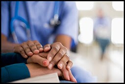 The figure above is a photograph showing a health care provider comforting a patient.