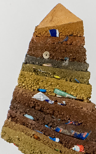 Layers of earth and litter in a small sculpture that shows how the sculpture will look like