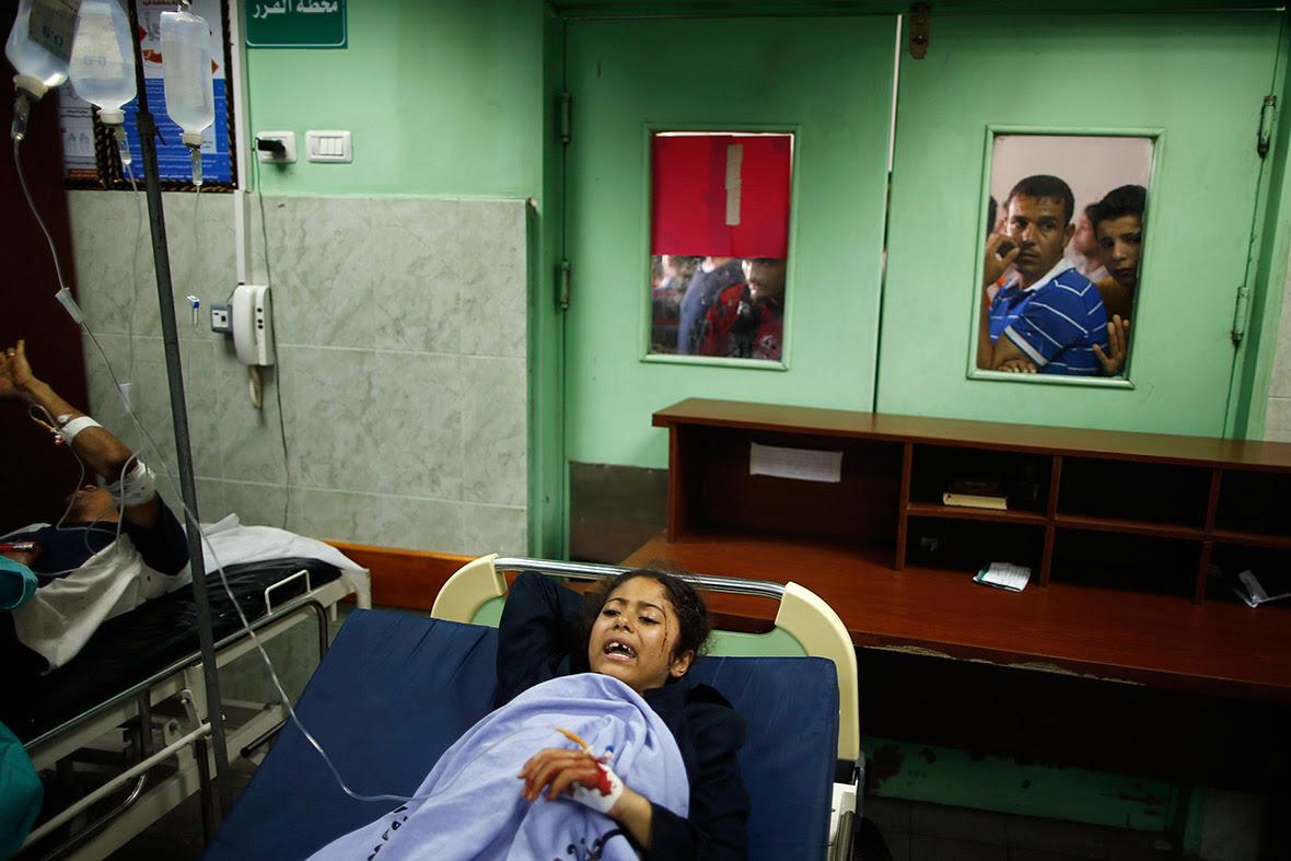 Worried Palestinians wait outside a hospital ward where a wounded girl is being treated