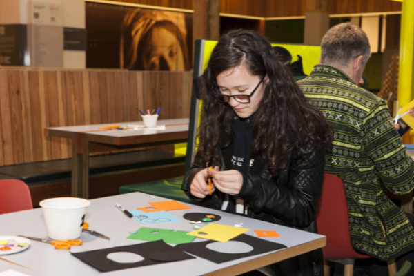 Image of a visitor taking part in arts and crafts during Night Owls