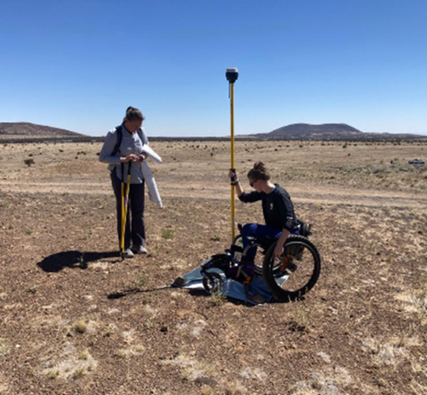 Color photograph of student taking measurement in the field