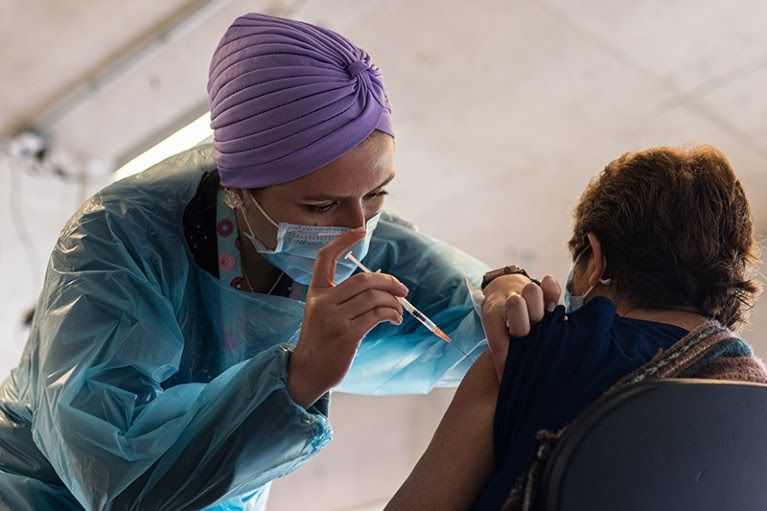 A healthcare worker inoculates a person with the fourth booster dose against Covid-19 in Viña del Mar, Chile.