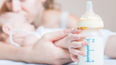 Baby Holding Breast Milk