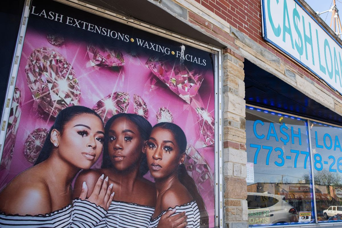 A loan store in the Ashburn neighborhood on Chicago’s South Side. An advertisement for beauty products featuring three young Black women is on the brick wall next to the loan store’s front door. An analysis of 2019 borrower data found an abundance of high-interest loans in majority Black neighborhoods. Industry groups say they lend money to people who don’t qualify for traditional bank loans.