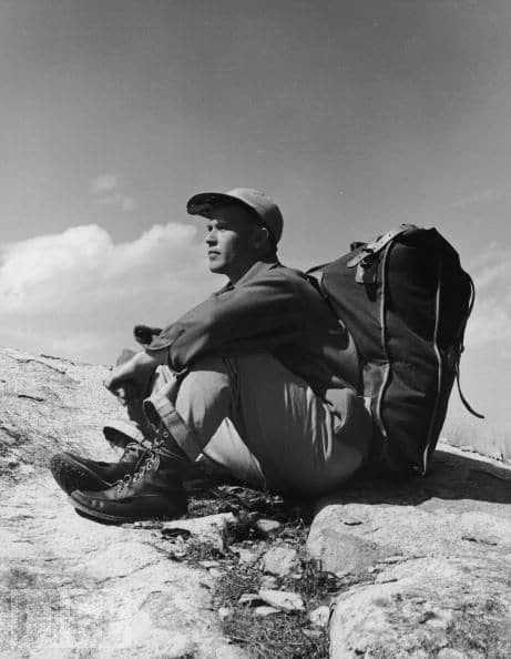 vintage hiker climber sitting on rock with pack